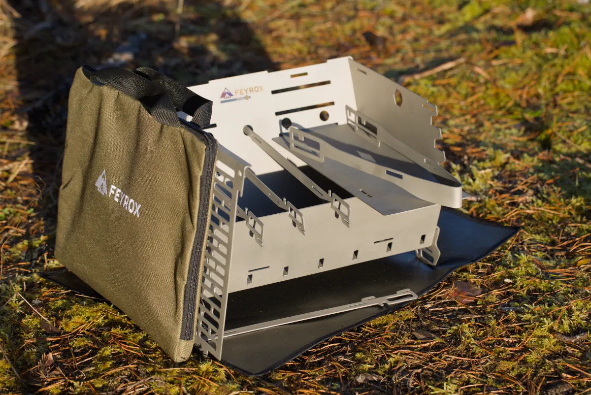 Titan1 folded beside its carry bag and heat-resistant base mat