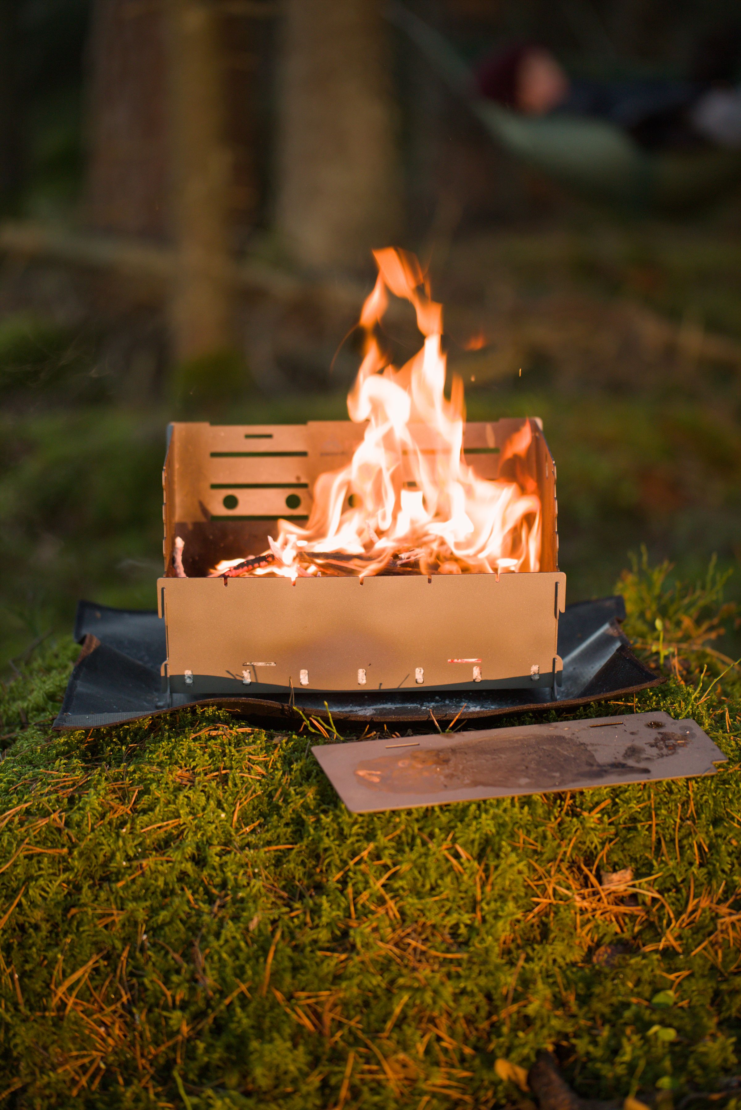 Titan1 titanium fire pit burning at dusk in the forest