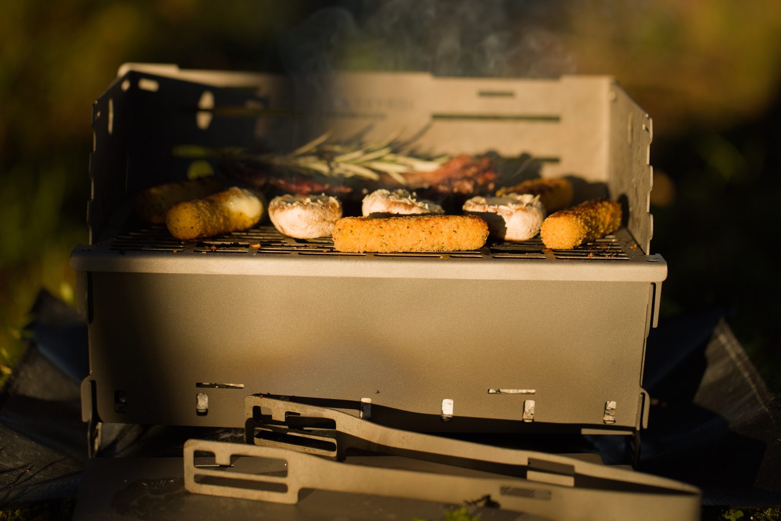 Sausages, mushrooms and steak cooking on the Titan1 grill