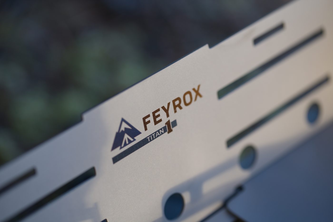 Close-up of the laser-cut titanium panel and Feyrox mark