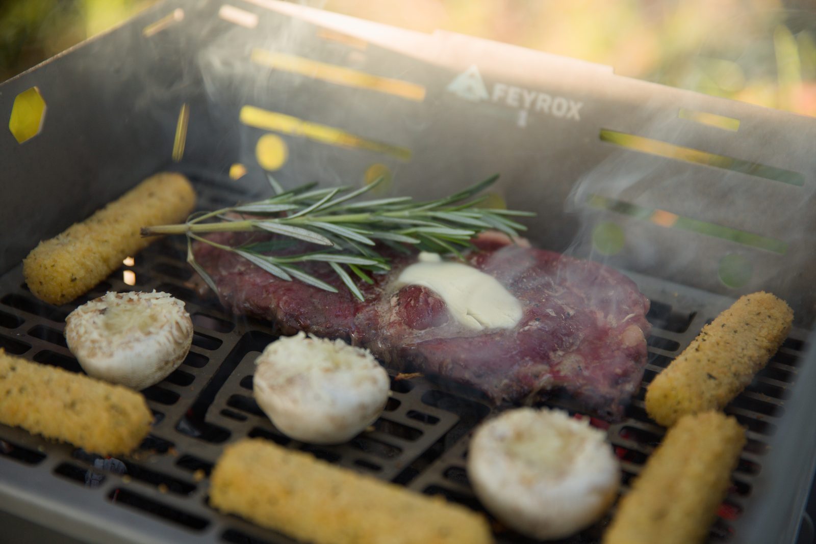 Steak with rosemary, sausages and stuffed mushrooms searing on the Titan1 grate