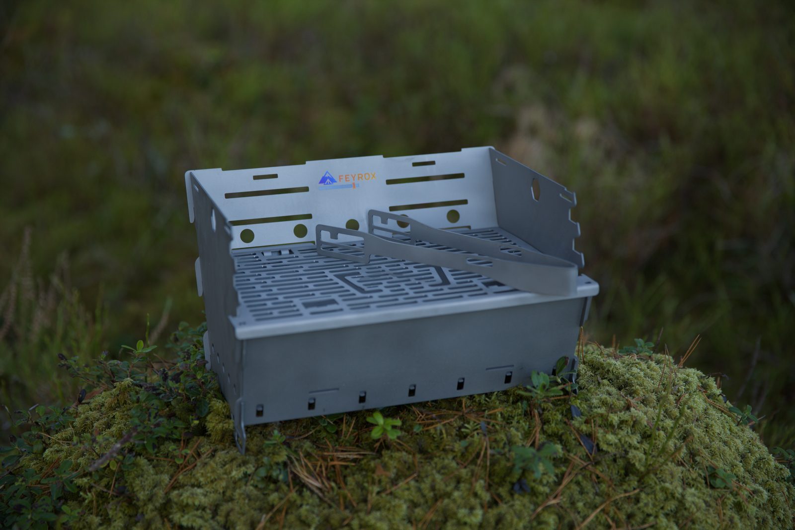 Titan1 titanium grill set up on moss, viewed from the side